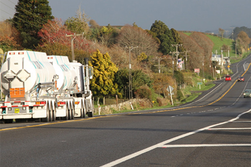 A truck and cars travelling along a rural state highway