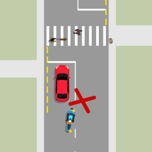 A red car is stopped at a pedestrian crossing and waiting for people to finish crossing. A blue motorcycle behind the red car is attempting to pass the red car. A large red X indicates this is the wrong thing to do.
