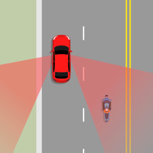 A red car is in the left lane. A blue motorcycle is riding behind the red car in the right lane. Shaded red areas show where the blind spots of the car are. The motorcycle in in the car's right blind spot 