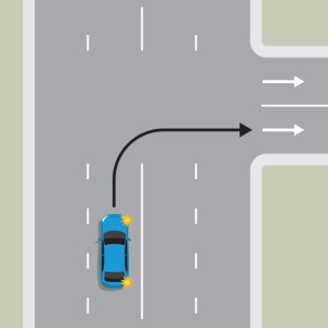 A blue car is turning right into a one-way street. They must sat in the lane through the intersection.