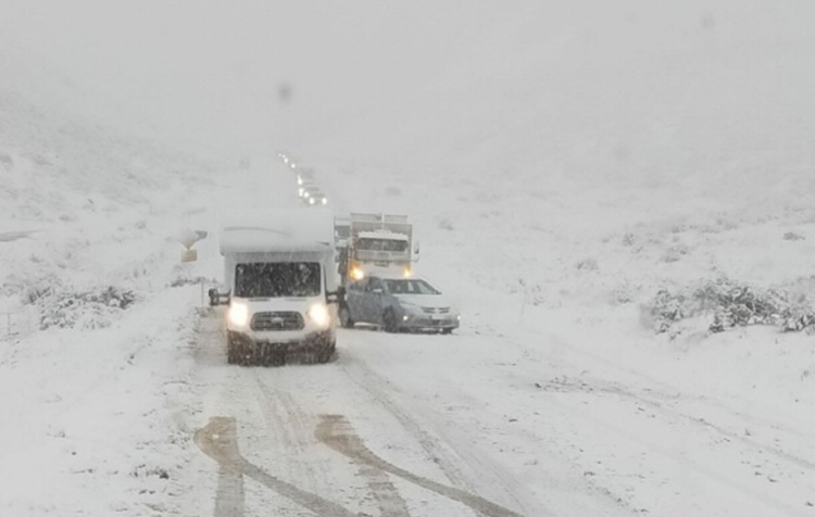 vehicles being towed on the road full of snow