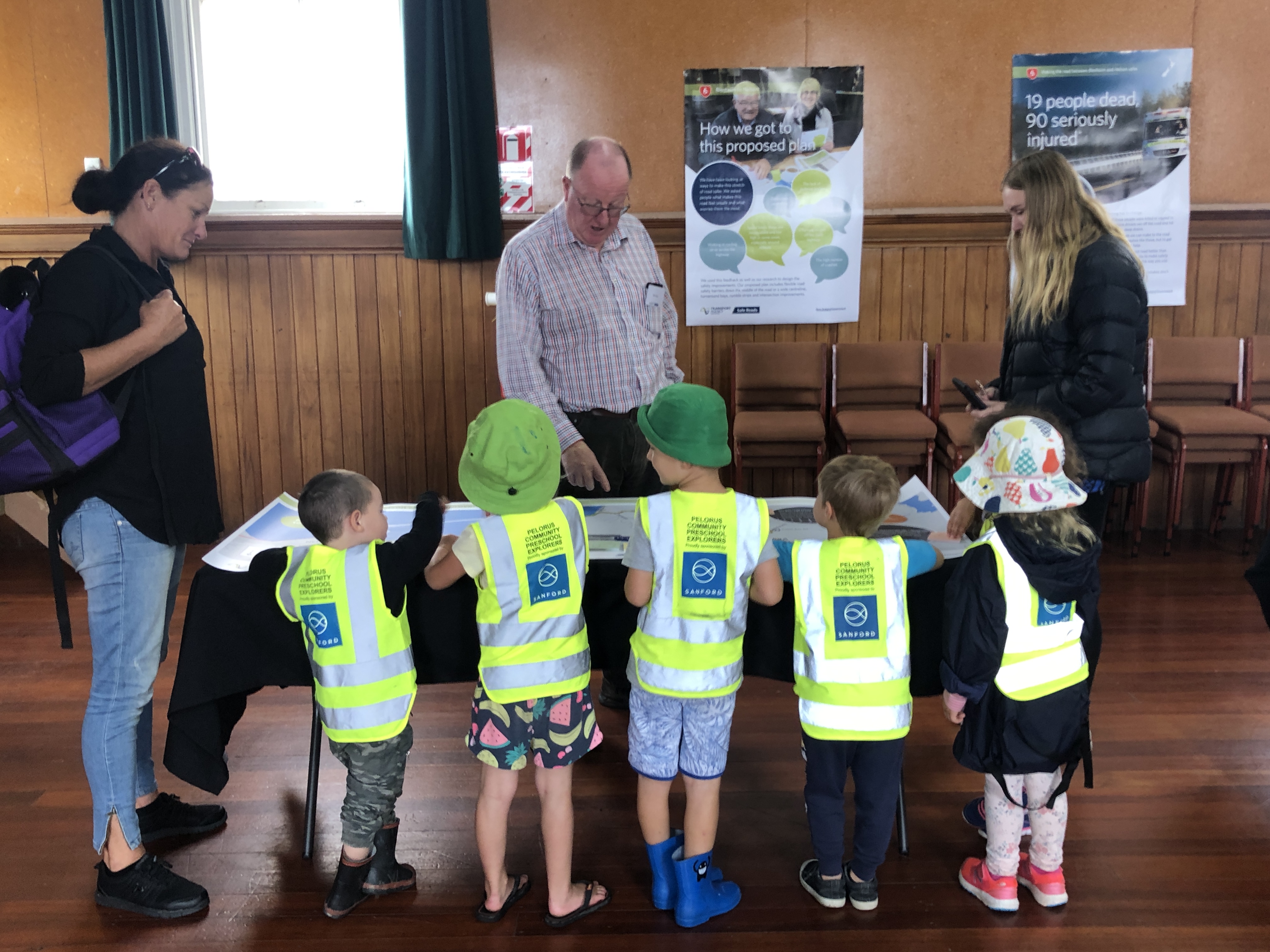 Five students from Pelorus Community Preschool with their teacher Lisa Brown on the left looking at a map of the speed review area which is laid out on a table.