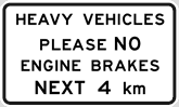 White information sign saying heavy vehicles please no engine brakes next 4km